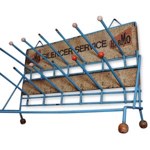 May include: A blue metal rack with wooden knobs and a sign that reads "Harmo Silencer Service".