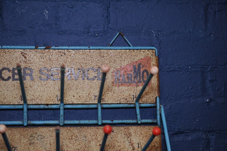 May include: A blue metal rack with hooks for hanging items. The rack has a sign that says "Car Service Remarkable".