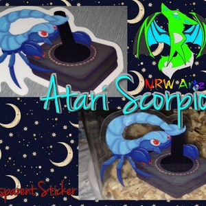 May include: A blue scorpion holding a joystick, with the text "Atari Scorpion" and "Transparent Sticker" on the image.
