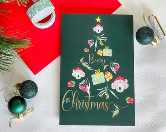 Have a Beary Christmas! Bottle green Koala seasonal card with gum leaves wattle and presents in the shape of a Christmas Tree