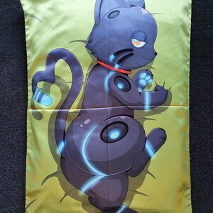 Puede incluir: Una funda de almohada rectangular con una ilustraci&oacute;n impresa de un gato rob&oacute;tico gris oscuro con detalles en azul brillante y un collar rojo. El gato aparece en posici&oacute;n reclinada sobre un fondo amarillo claro con sutiles detalles de l&iacute;neas.
