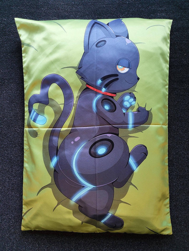 Puede incluir: Una funda de almohada rectangular con una ilustraci&oacute;n impresa de un gato rob&oacute;tico gris oscuro con detalles en azul brillante y un collar rojo. El gato aparece en posici&oacute;n reclinada sobre un fondo amarillo claro con sutiles detalles de l&iacute;neas.