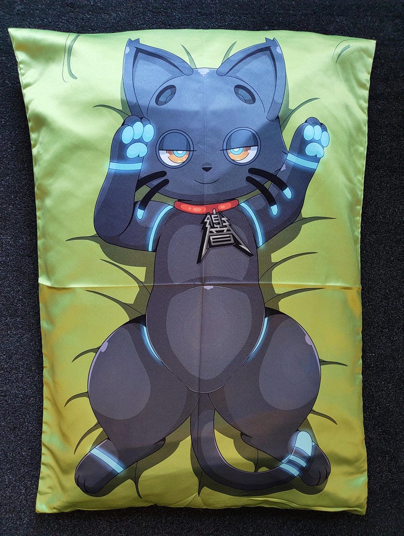 Puede incluir: Una funda de almohada rectangular con una ilustraci&oacute;n gr&aacute;fica de un gato gris oscuro con detalles en azul brillante en las extremidades y orejas. El gato lleva un collar rojo con un colgante met&aacute;lico sobre un fondo de color verde lima.
