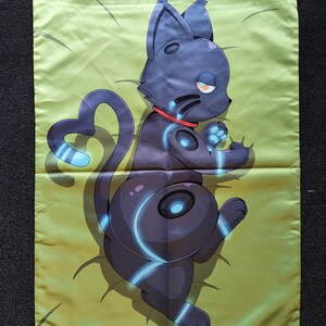 Puede incluir: Una funda de almohada rectangular con fondo verde claro y una ilustraci&oacute;n impresa de un gato estilizado de color gris oscuro. El gato tiene un collar rojo, marcas circulares de color azul brillante en el cuerpo y una cola en forma de coraz&oacute;n.