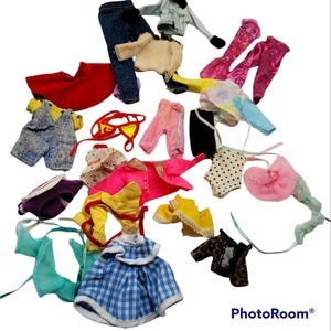 May include: A collection of doll clothes in various colors and patterns, including a blue gingham dress, a yellow and red striped top, a pink and white polka dot dress, and a blue denim overall.