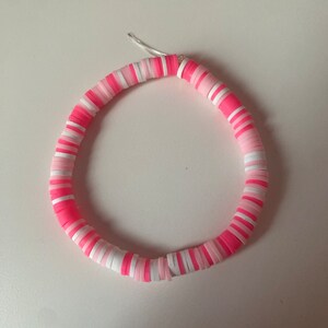 Könnte beinhalten: Rosa-weißes Perlenarmband mit schlichtem Design.