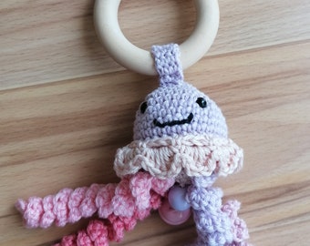 Rattle and grasping toy in one, teething ring with crocheted jellyfish, lilac/pink