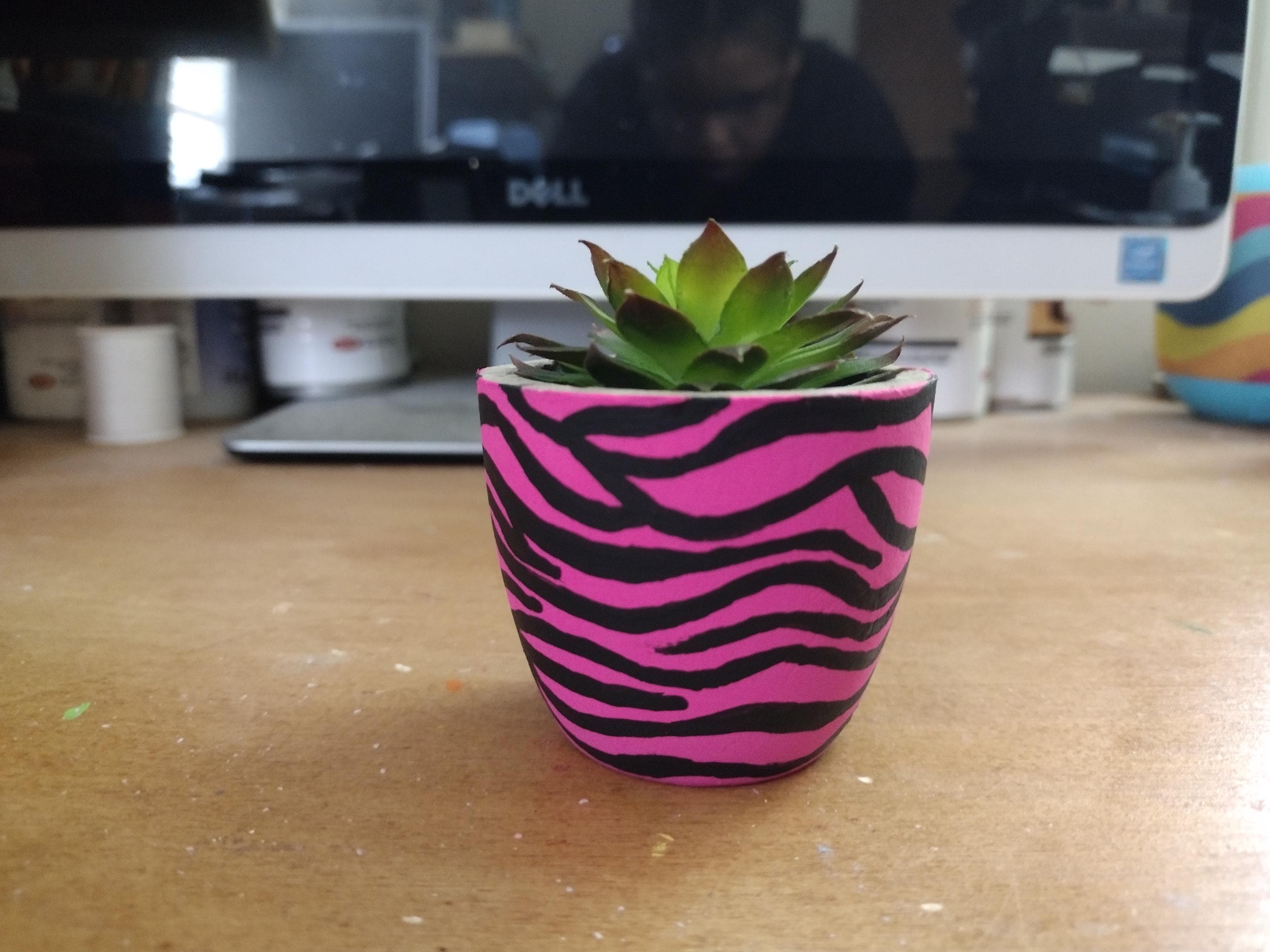 faux succulent with hand painted pink and black zebra like stripe pot for desk or shelf decor.