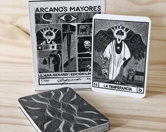 May include: A black and white tarot card deck featuring a black and white illustration of an angel pouring water from a pitcher. The card is titled "LA TEMPERANCIA" and numbered 14. The deck is part of a limited edition set of 100.