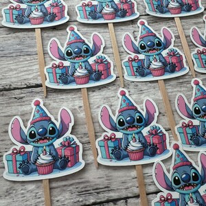 May include: A set of 10 blue Stitch cupcake toppers with a birthday hat, holding a cupcake with a candle and a gift box. The toppers are printed on white cardstock and attached to wooden sticks.