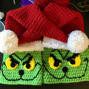 May include: A pair of green crocheted Grinch-themed boot cuffs with white fur trim and red crocheted Santa hats with white pom-poms.