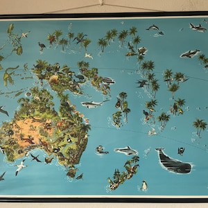 Puede incluir: Un mapa educativo vintage que representa un mapa de Australia y las islas circundantes con varios animales y plantas. El mapa está sobre un fondo azul con un marco negro.