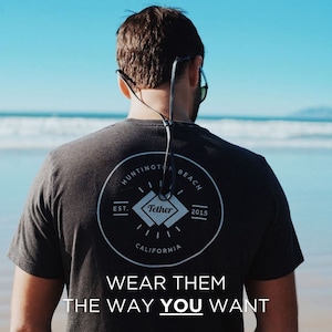 K&ouml;nnte beinhalten: Eine Person tr&auml;gt ein schwarzes T-Shirt mit einem wei&szlig;en Kreislogo, auf dem "Huntington Beach Est. 2015 California" und ein Diamant mit dem Wort "Tether" stehen. Der Text "Wear them the way you want" ist unter dem Logo gedruckt.