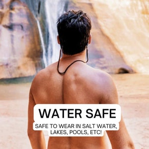 Peut inclure: Un homme debout devant une cascade avec le texte "WATER SAFE SAFE TO WEAR IN SALT WATER, LAKES, POOLS, ETC!" sur une &eacute;tiquette blanche.