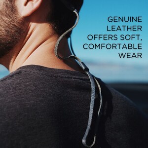 K&ouml;nnte beinhalten: Nahaufnahme einer Person, die ein schwarzes T-Shirt mit einem Lederband um den Hals tr&auml;gt. Der Text "GENUINE LEATHER OFFERS SOFT, COMFORTABLE WEAR" ist auf dem Bild zu sehen.