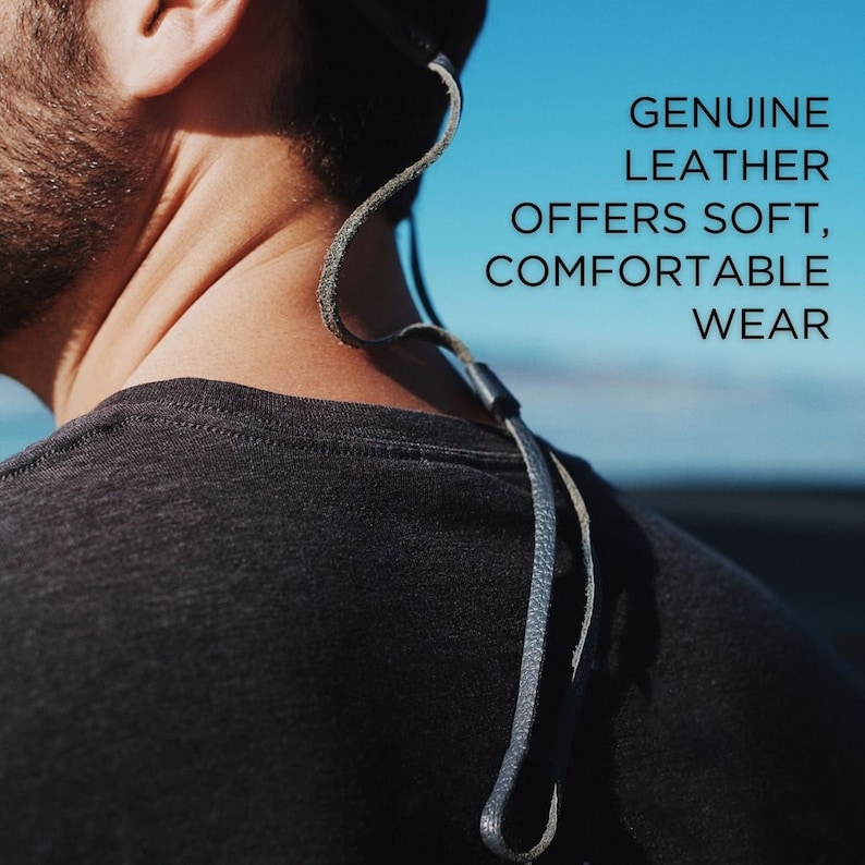 K&ouml;nnte beinhalten: Nahaufnahme einer Person, die ein schwarzes T-Shirt mit einem Lederband um den Hals tr&auml;gt. Der Text "GENUINE LEATHER OFFERS SOFT, COMFORTABLE WEAR" ist auf dem Bild zu sehen.