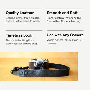 May include: A black leather camera strap with a diamond-shaped logo. The strap is made of genuine leather and is designed to be durable and comfortable. The strap is shown attached to a silver and brown camera.