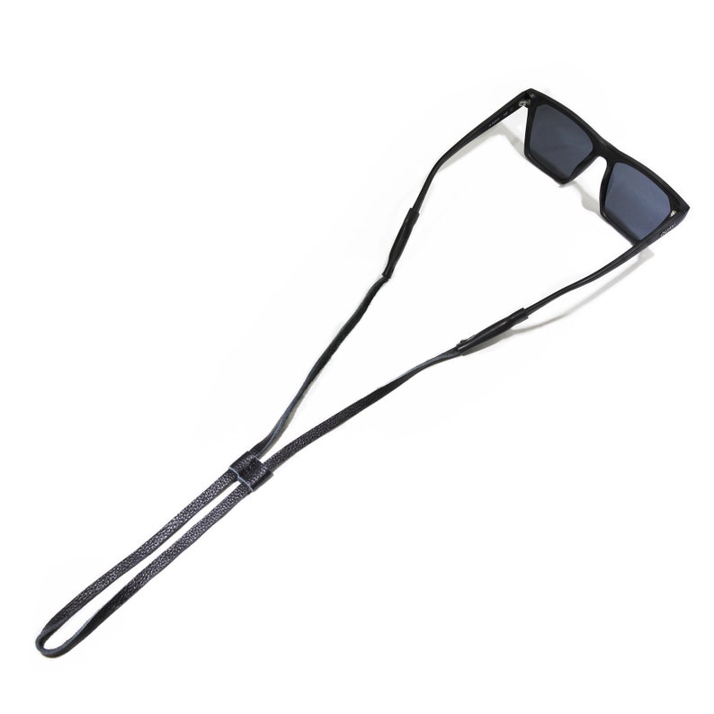 K&ouml;nnte beinhalten: Schwarzes Leder-Sonnenbrillenband mit verstellbarer L&auml;nge. Das Band ist so konzipiert, dass es die Sonnenbrille sicher um den Hals h&auml;lt.