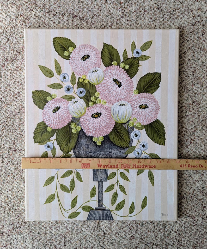 May include: An original painting of a floral arrangement in a gray vase. The flowers are pink and white, with green leaves and blue accents. The background is striped with beige and white. The painting is approximately 16 inches wide.