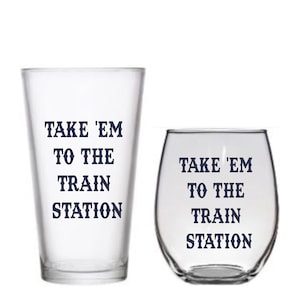 May include: Two clear glass cups with the text "Take 'em to the train station" printed in dark blue on them.