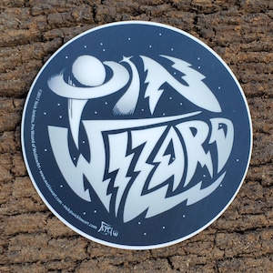 Peut inclure: Un autocollant rond avec un fond bleu foncé et des lettres blanches. L'autocollant présente les mots "On Wizard" dans une police stylisée avec des éclairs. Le fond est rempli d'étoiles blanches.
