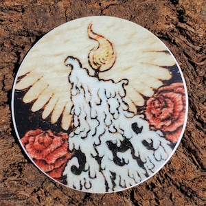 Könnte beinhalten: Eine weiße Kerze mit einem tropfenden Wachsdesign, umgeben von roten Rosen. Die Kerze befindet sich auf einem Holzgrund.