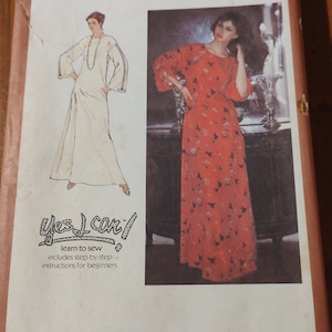 May include: Simplicity sewing pattern number 8743 for a dress. The pattern includes instructions for beginners and features two models wearing different styles of dresses. One dress is white and the other is red with a bird print.