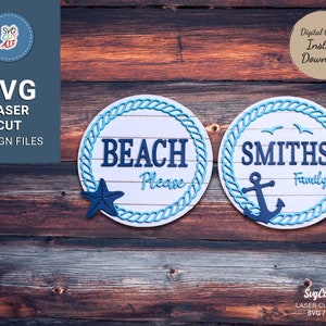 Puede incluir: Dos letreros redondos de madera con ribete de cuerda. El primer letrero dice "BEACH Please" con una estrella de mar. El segundo letrero dice "SMITHS Family" con un ancla.
