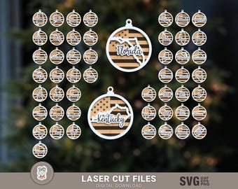 Pode incluir: Um conjunto de 50 designs de ornamentos cortados a laser que apresentam os contornos de diferentes estados dos EUA. Os ornamentos são em preto e branco com o nome do estado escrito dentro de cada um. Os ornamentos estão dispostos em um padrão de grade sobre um fundo verde.