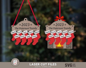 May include: Two wooden Christmas ornaments with the text "*2023* The Paterson Family" and a row of stockings with names printed on them. One ornament has a fireplace design with a fire.