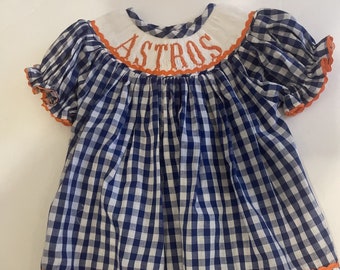 Hand Smocked Astro Dress! The bright blue and orange will make your little one shine bright!