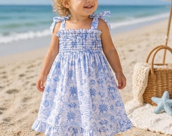 Precioso vestido de playa azul y blanco para bebés y niñas pequeñas. El vestido se ata a los hombros con un cinturón.