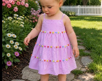 Adorable Pink Pom Pom sundress for baby girls and toddlers. The dress ties int he back with a sash.