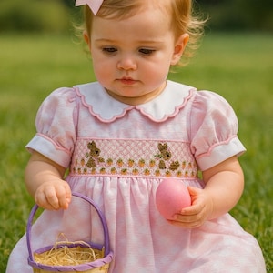 Beautiful hand smocked pink  Easter dress trimmed in pink with cute bunnies across the bodice.