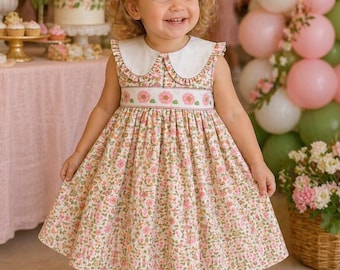 Un precioso vestido rosa de niña pequeña con fruncido, ideal para heredar. El corpiño fruncido con flores es adorable. Este bonito vestido también tiene bolsillos.