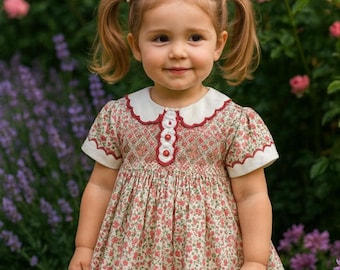 A beautiful heirloom smocked in shades of pink floral toddler dress. This dress is so special that the sleeves are smocked.
