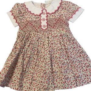 A beautiful heirloom smocked in shades of pink floral toddler dress. This dress is so special that the sleeves are smocked.