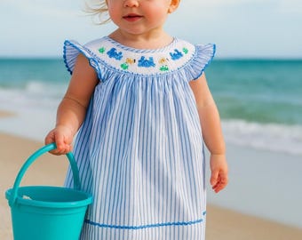Charming hand smocked blue dress bishop neckline, beautifully adorned with playful crabs and fish and designed with lovely butterfly sleeves