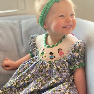 Hand smocked dress with Peter Pan and friends around the bishop style  neck.