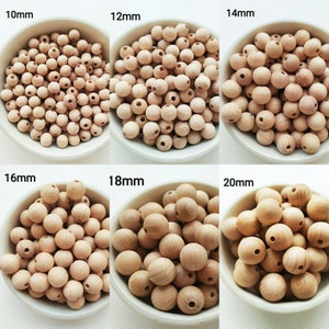 Op de afbeelding: Zes kommen met houten kralen in verschillende maten, van 10 mm tot 20 mm. De kralen zijn van natuurlijke houtkleur en hebben een gladde, ronde vorm.