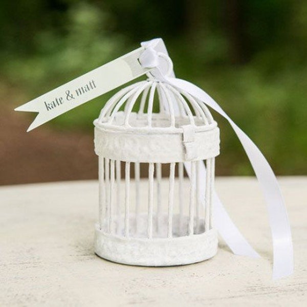 The mini white bird cage carries wedding rings