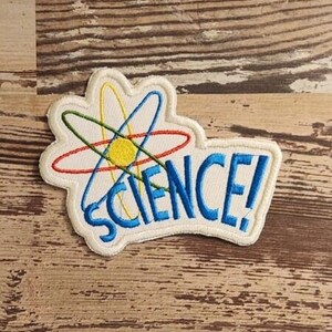 May include: White embroidered patch with a colorful atom symbol and the text "SCIENCE!" in blue.