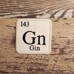 May include: A white square patch with a black border and the text "143 Gn Gin" on it.