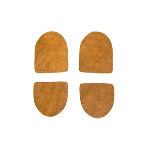 May include: Four brown leather patches with stitched edges. The patches are in the shape of a rectangle and a half-circle.