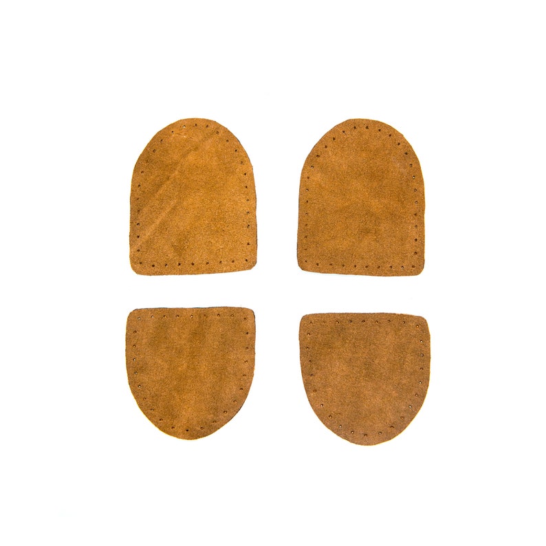 May include: Four brown leather patches with stitched edges. The patches are in the shape of a rectangle and a half-circle.