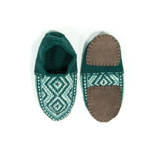 May include: A pair of green knitted slippers with a geometric pattern and brown suede soles.