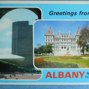 Carte postale vintage 1976, salutations d'Albany, New York montrant le capitole de l'État et le Rockefeller Empire State Plaza en excellent état vintage