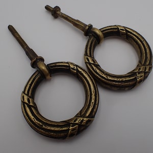 Peut inclure: Deux tirettes en laiton antique avec un design de corde décoratif. Les tirettes ont une vis au dos pour être fixées à une surface.