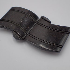 May include: A black, carved, wooden, decorative piece shaped like a banner with two parallel lines running down the length of the piece.