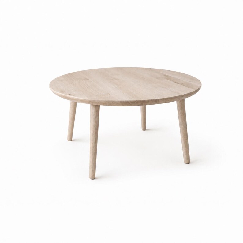 Puede incluir: Mesa de centro redonda de madera clara, con cuatro patas c&oacute;nicas. La mesa tiene un acabado de veta de madera natural y un dise&ntilde;o minimalista. La mesa tiene aproximadamente 76 cm de di&aacute;metro.
